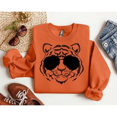 Are you a dedicated Cincinnati Bengals fan looking to step up your game day style? Look no further! Our Cincinnati Bengals Sweatshirt is the perfect way to showcase your unwavering support for the team, stay cozy, and look effortlessly stylish. Whether you're cheering from the stands at Paul Brown Stadium, hosting a game day gathering, or simply watching from home, this sweatshirt ensures you're doing it with style. Don't miss the chance to elevate your fan wardrobe and make a bold statement of your Bengals pride. Order our Cincinnati Bengals Sweatshirt today and be the envy of your fellow fans! Perfect for game day, tailgating, or everyday wear, this sweatshirt is a must-have for any Bengals fan. Show your love for the team and the Queen City in style with this fantastic addition to your Casual Black Sweatshirt For Football Season, Fall Fan Gear Sweatshirt With Graphic Print, Fan Gear Graphic Print Sweatshirt For Fall, Fall Fan Gear Graphic Sweatshirt, Team-colored Sweatshirt With Team Logo For Fall, Team-colored Fall Sweatshirt With Team Logo, Trendy Game Day Crew Neck Sweatshirt, Game Day Fan Apparel Sweatshirt For Fall, Fall Varsity Sweatshirt With Team Logo