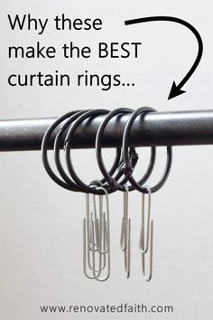 there are five rings hanging from the rail with hooks attached to each other and an arrow pointing up at them