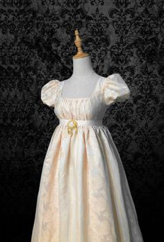 This is a beautiful Bridgerton-inspired dress in a beige and yellow jacquard fabric. It has a fitted bodice with a square neckline and puff sleeves. The skirt is full and gathered, with a yellow sash at the waist. The dress is perfect for a regency-themed event or party. Details: puffy sleeves, Ruched bodice, Cinnamon jacquard chiffon Length: Long (Dress length can be customized) Neckline: scoop Waistline: high-waisted Silhouette: A line Regency Shoes, Bridgerton Experience, Bridgerton Daphne, Regency Ball, Bridgerton Party, Antoinette Dress, 18th Bday, Jane Austin, Regency Dress