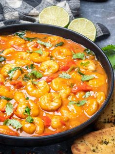 a black bowl filled with shrimp and garnished with cilantro