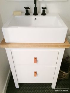 a bathroom sink with two faucets on the top and one drawer below it