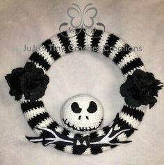 a crocheted skull wreath with black and white flowers on it, sitting in front of a white background