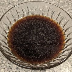 a glass bowl filled with brown liquid on top of a counter