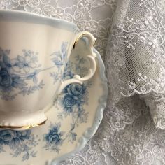 a tea cup and saucer on a lace tablecloth