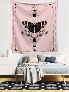 a pink wall hanging over a bed with a butterfly tapestry on it's side