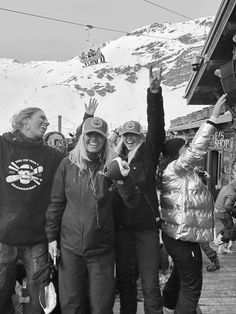 black and white photograph of people standing in front of a ski lodge