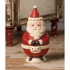 a santa clause figurine holding a small child