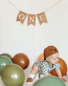 a baby is crawling on the floor in front of balloons