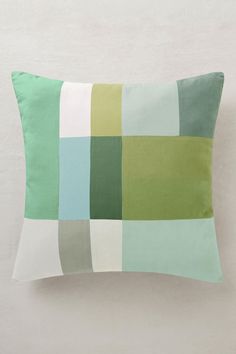 a green and white pillow sitting on top of a wall