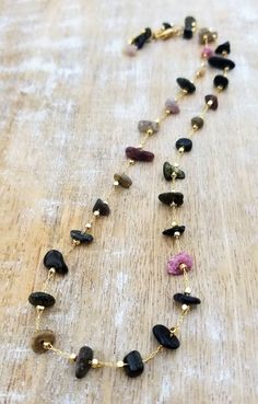 Tourmaline Beaded Necklace, Gemstone Chip Necklace, Multi Color Tourmaline, Natural Tourmaline Necklace Gold, October Birthstone This multi color tourmaline gemstone necklace is the perfect year-round necklace! It is a natural, dainty, lightweight, and striking! The tourmaline chip gemstones display black, brown, green, and pink colors. They range in size from about 6mm to 15mm. The total length of the necklace is approximately 21 inches and is finished with a gold plated lobster claw clasp. Thi Healing Tourmaline Gemstone Bead Necklaces, Tourmaline Beaded Necklaces For Jewelry Making, Spiritual Tourmaline Gemstone Bead Necklaces, Tourmaline Necklace With Natural Stones And Round Beads, Spiritual Tourmaline Gemstone Bead Necklace, Tourmaline Beaded Necklaces With Round Natural Stones, Gemstone Chip Necklace, Chip Necklace, Round Necklace