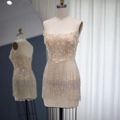 In stock and ready to ship in 2-3 business days! This transparent rhinestone and fringe tassel mini dress is perfect for any occasion! In addition to the faux pearl and rhinestone embellished bodice, this dress features cascading layers of sparkling crystals tassels along the bottom, providing eye-catching sparkle.There is a bra cup built into the dress. If you want coverage in those special areas, a bra, underwear, slip or whatever you choose can be worn underneath! Material: polyester, tulle C Elegant Beaded Fringe Mini Dress For Party Season, Elegant Beaded Fringe Mini Dress For Cocktail, Elegant Cocktail Mini Dress With Beaded Fringe, Pearl Dresses, Cascading Layers, Bra Cup, Pearl Dress, Tassel Fringe, Sparkling Crystal