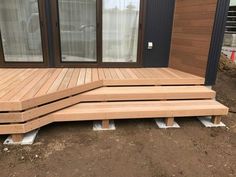 three wooden steps sitting next to each other on the side of a building with windows