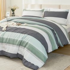 a bed with blue and white striped comforters