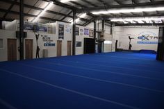 an indoor gym with blue carpet and white walls