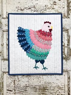 a quilted wall hanging with a rooster on it