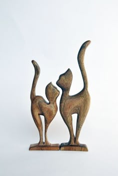 two wooden cats standing next to each other