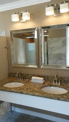 a bathroom with two sinks and mirrors in it