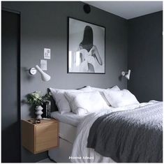 a bed with white sheets and pillows in a bedroom next to a painting on the wall