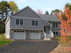 a two story house with garages in the driveway