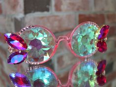 ADULT sized new circle frame lightshow funglasses with kaleidoscope lens, decorated with big fancy glass rhinestones. These glasses have a fantastic shine in the sunlight, but are also incredible as a nighttime concert accessory. The kaleidoscope glass creates spectacular patterns when looking at a lightshow. *Please note, this pair is somewhat heavy due to the kaleidoscope glass* *Not to be used as sunglasses; these offer no UV protection* **NOT RECOMMENDED IF YOU GET MOTION SICKNESS** Custom c Kaleidoscope Glasses, Motion Sickness, Circle Frame, Circle Frames, Light Show, Faceted Glass, Eyewear Sunglasses, Crystal Rhinestone, Custom Color