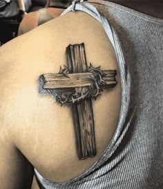 a man with a cross tattoo on his shoulder