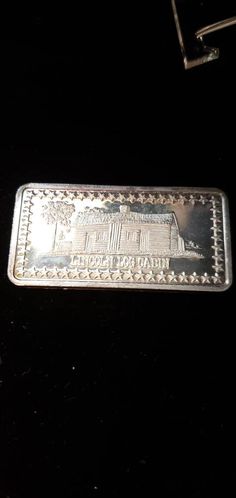 a silver bar sitting on top of a black table next to a keychain