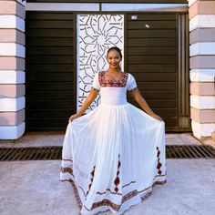 a woman in a white dress is posing for the camera