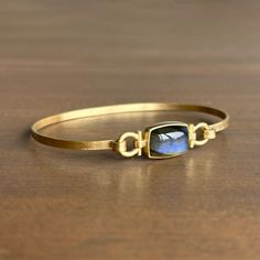 A mercurial labradorite is the centerpiece of this splendid gold bracelet. 18k yellow gold Labradorite, 6.92ct, 13mm x 9mm (1/2" x 3/8") Bracelet circumference is 7.32” Elegant Gold Labradorite Bracelets, Rectangular Gemstone Bracelet In Yellow Gold, Rectangular Yellow Gold Bracelet With Gemstone, Newport Ri, Gift Card Shop, Bracelet Gift, Ring Necklace, Newport, Jewelry Care