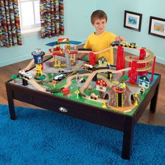 a young boy playing with his toy train set