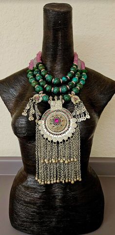 Huge 20 mm luxury turquoise round beads are each separated by pink rhinestone rondelles in this big, bold, heavy and dramatic showstopper tribal - ethnic beaded chest piece. The back of the necklace is finished with two shades of frosted pink glass beads and silver tone tribal spacers. The focal point is a big vintage Waziri Architectural Dome Pendant which measures approximately 9.5" x 4.5". The pink and green inlaid glass is intact, as are all the chain dangles. Two smaller charm dangles flank Luxury Traditional Beads, Gems, And Cabochons, Luxury Large Beaded Amulet Necklace, Luxury Statement Beads, Gems, And Cabochons, Turquoise Western, Jewellery Shop Design, Artisan Multicolor Large Beads, Gems, And Cabochons, Chest Piece, Luxury Bohemian Agate Beads, Gems And Cabochons, Small Charms