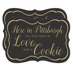 a black and gold sign that says here in pittsburgh all you need is love and a cookie