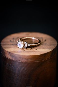 a wooden box with a ring on it and two stones in the middle, sitting next to each other