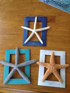 three starfishs and two seashells are sitting on a table top together