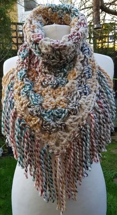 a multicolored knitted scarf on top of a white mannequin