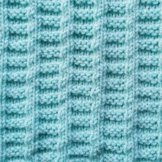 a close up view of a blue knitted blanket