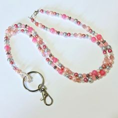 Dress up your ID holder with this Beautiful Peach Beaded Lanyard. If you wear a badge for work every day, these lanyard necklaces are a great way to brighten up your outfit.  This lanyard measures approx. 38 inches. It is made with shades of peach & grey faux pearls and glass beads with antique silver beads. It has a swivel lobster clasp to hold your employee ID, work badge or your keys.  This lanyard is made with 49 strand Jewelry wire for maximum durability. All of my items are handmade in Pri Pink Beaded Lanyards For Gifts, Healthcare Appreciation, Lanyard Necklace, Badge Lanyard, Beaded Lanyard, Work Badge, Shades Of Peach, Beaded Lanyards, Prince Edward Island