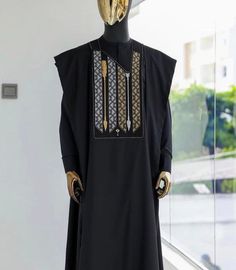 a mannequin dressed in black with gold accents