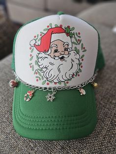 a green and white hat with a santa clause on it's front, sitting on a couch