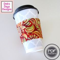 a coffee cup with a red and yellow design on the bottom is sitting next to a white wall