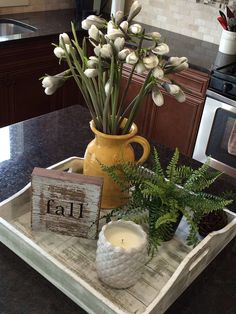 a tray with some flowers and candles on it