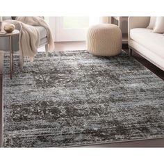 an area rug with grey and white colors on the floor in a modern living room