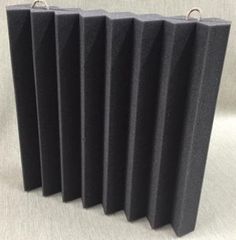 four black acoustic foams are lined up on a white surface with two silver handles