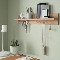 a desk with a laptop, phone and other office supplies on the shelf above it