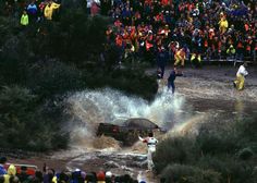 a car is stuck in the mud as people watch