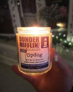 a person holding up a lit candle with the words upside down in front of them