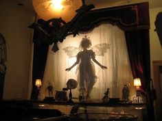 an image of a woman standing in front of a curtain with candles on it and lights behind her