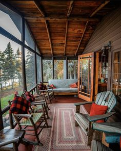 a porch with rocking chairs on it and lots of windows