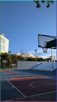 an empty basketball court surrounded by tall buildings