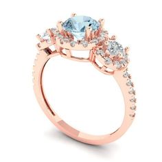 a rose gold engagement ring with an aqua blue topazte and white diamonds