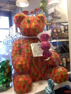 a large gummy bear sitting on top of a counter next to other items in a store